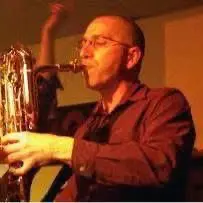 Man playing saxophone in warm lighting.